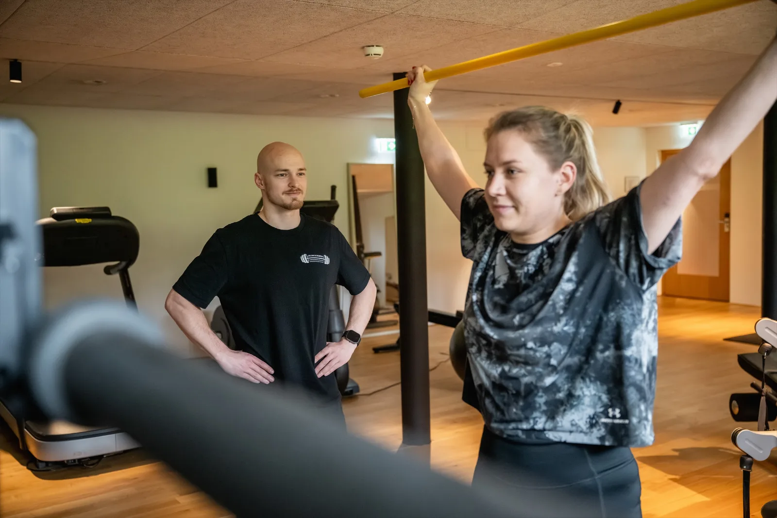 Julian Schuster begleitet eine Kundin aufmerksam beim Training